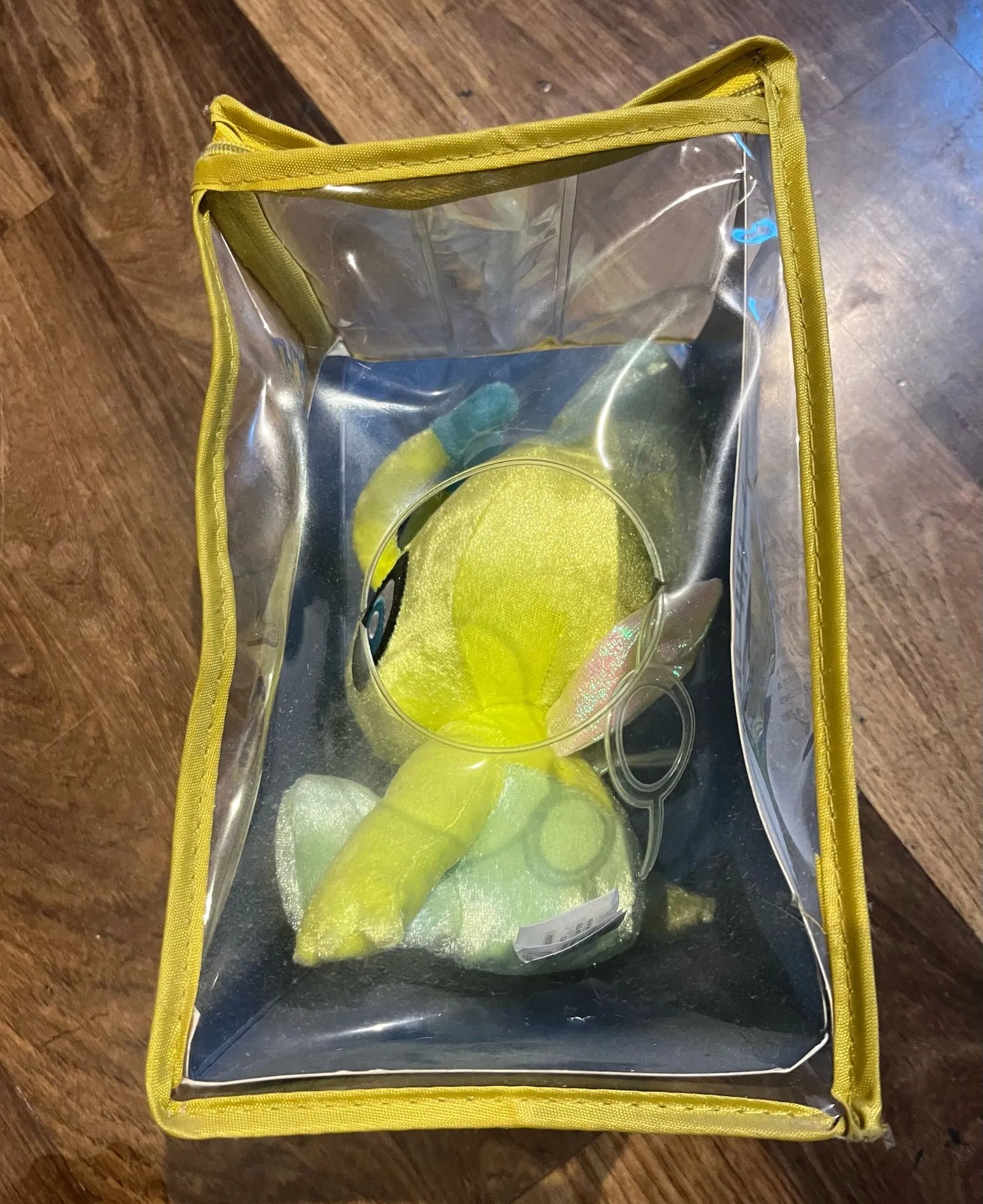 Vue du côté gauche de la peluche Pokémon officielle TOMY – Celebi N°251 Légendaire dans sa boîte